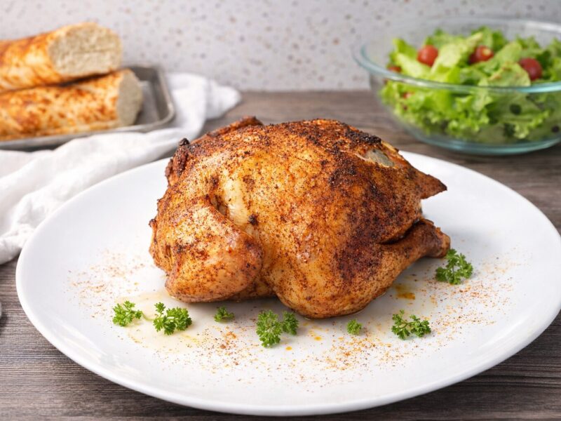 How long to smoke a whole chicken at 225 - crisp golden skin on a wooden board