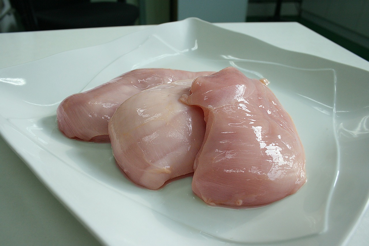 chicken breast on the stove &mdash; raw boneless skinless fillets ready for dry-brining before pan-searing