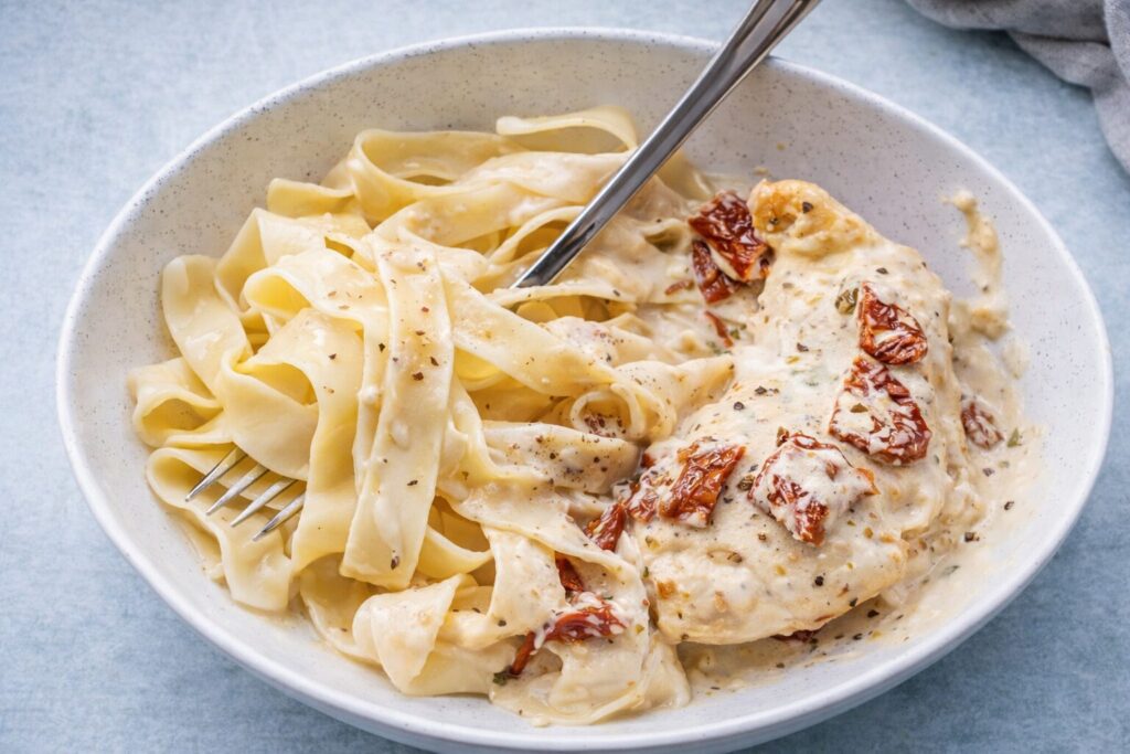 Creamy chicken pasta with sun-dried tomato in a bowl