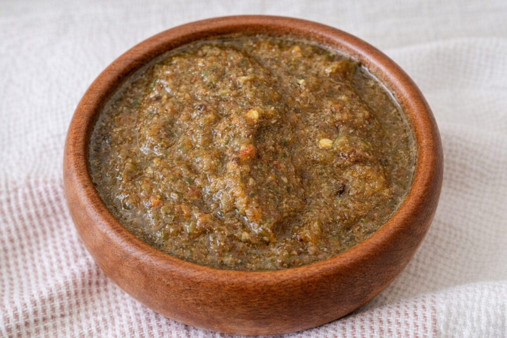 Authentic Jamaican jerk chicken seasoning wet marinade paste with allspice, thyme and scotch bonnet in a wooden bowl