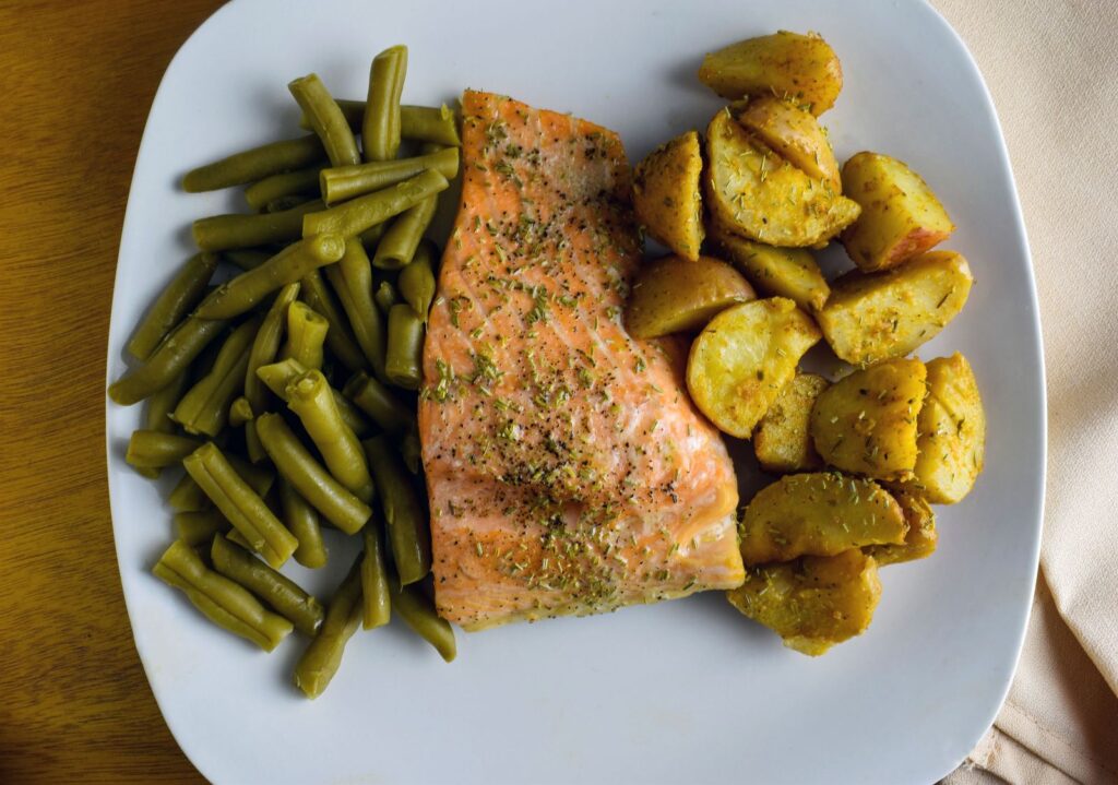 Baked sockeye salmon recipe — plated salmon fillet with green beans and roasted potatoes