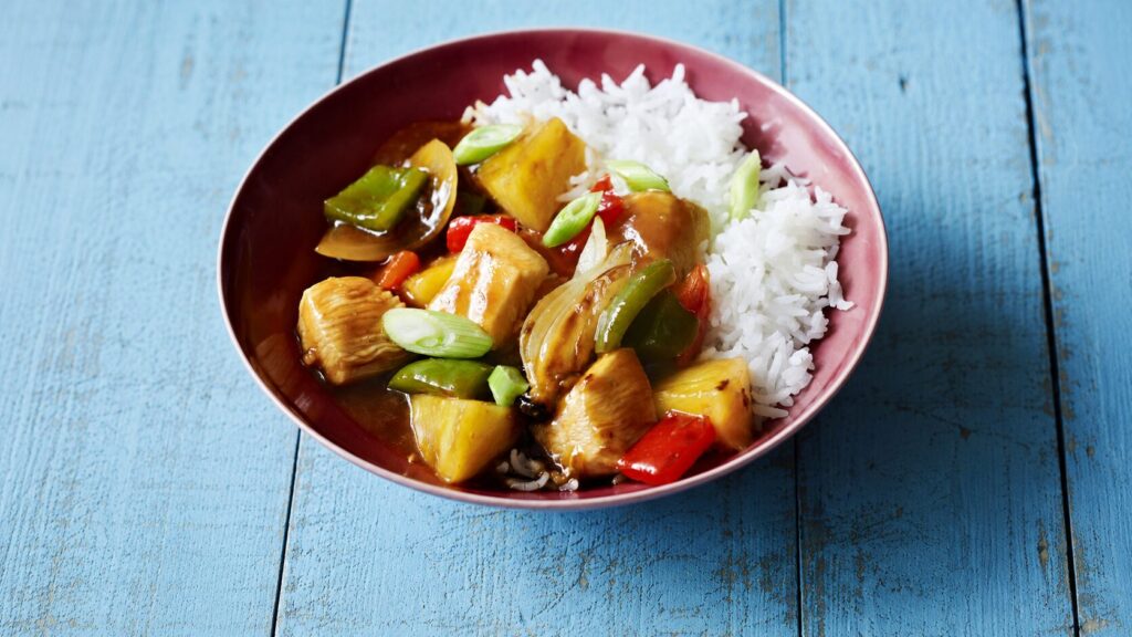 Sweet and sour chicken with pineapple and bell peppers in a glossy sauce