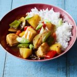 Sweet and sour chicken with pineapple and bell peppers in a glossy sauce