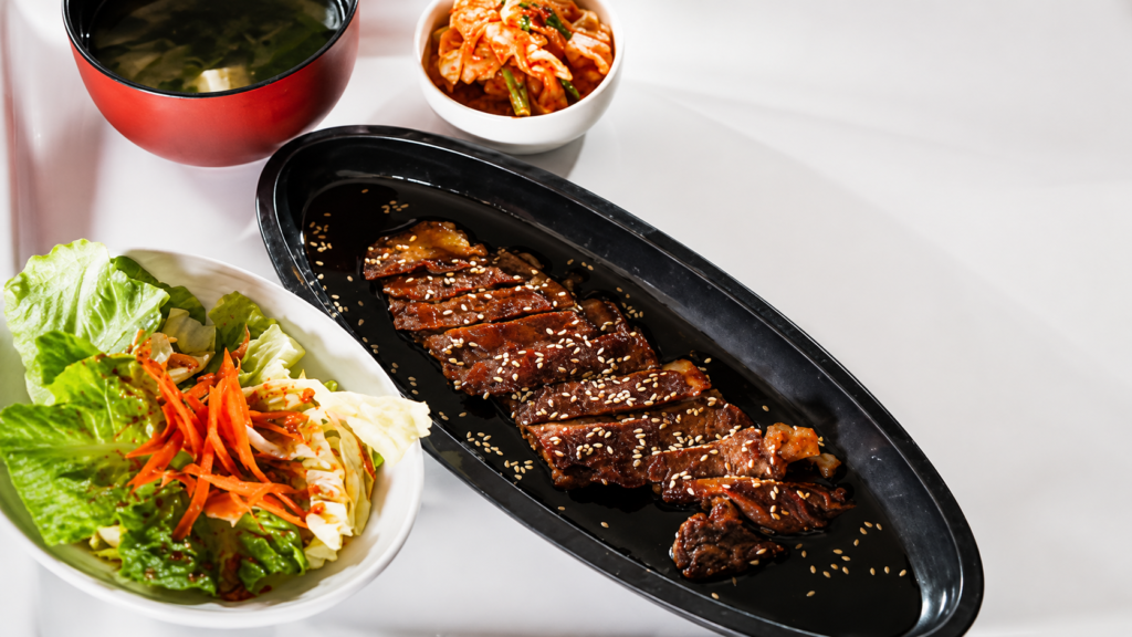Beef Teriyaki with Real Japanese Sauce (15 Minutes) Shine-glazed beef, four-ingredient sauce, over hot rice. No garlic, no ginger — that's not teriyaki. Quick answer: Real Japanese teriyaki sauce is 4 ingredients only — soy sauce, sake, mirin, sugar, mixed 2:2:2:1. Simmer 8 minutes until it coats a spoon. Sear thinly sliced beef in a hot pan 60 seconds per side, add sliced onion and the sauce, glaze 90 seconds. Serve over rice with sesame and sliced scallion. Fifteen minutes start to bowl. No garlic, no ginger — that's the American takeout version. Prep5 min Cook10 min Total15 min Serves2 StyleJapanese (teriyaki-yaki) What Real Teriyaki Sauce Actually Is Teri (照り) means shine or glaze; yaki (焼き) means grill. Together: shine-grilled. The whole point is the glossy caramelized coating you get from reducing a specific 4-ingredient sauce over hot meat — nothing else. Real Japanese teriyaki has no garlic, no ginger, no honey, no cornstarch. As Namiko Chen at Just One Cookbook writes, "westernized versions are sweetened with honey and flavored with garlic and ginger" — that's a different sauce with the same name slapped on it. The 4 ingredients are soy sauce (salt + umami), sake (depth + tenderizer), mirin (sweetness + shine), sugar (extra body). Mix 2:2:2:1, simmer, done. The Ingredients (Beef + Real Sauce) For the sauce (makes ¾ cup, enough for 3–4 dinners) ¼ cup soy sauce — Japanese-style like Kikkoman, not Chinese light soy ¼ cup sake — Japanese rice wine, not cooking wine; dry sherry works if desperate ¼ cup mirin — sweet rice wine; the "hon-mirin" bottles are the real thing, "aji-mirin" is the mass-market fake 2 tbsp granulated sugar — regular white sugar; not honey, not brown For the beef teriyaki (serves 2) ¾ lb (12 oz) beef sirloin or ribeye, sliced ¼-inch thick across the grain — freezer-firm meat is easier to slice thin (see our how to slice beef thin guide) 1 yellow onion, halved and sliced ½-inch thick with the grain (they hold shape) 1 tbsp neutral oil — vegetable, avocado, or grapeseed. Not olive. 1 tsp toasted sesame seeds for finishing 2 scallions, thinly sliced on the bias Kosher salt, freshly ground pepper Serve over short-grain Japanese rice — walk through our how to cook Japanese rice guide if you've only ever done long-grain. How Do You Make Real Teriyaki Sauce? Combine the four ingredients in a small saucepan. Bring to a boil over medium heat, whisking until the sugar dissolves. Drop to medium-low and simmer 8–10 minutes until reduced by a third. You want it to coat the back of a spoon and hold a line when you drag your finger through — like maple syrup, not motor oil. The sake burns off alcohol in the first 2 minutes; the mirin caramelizes; the soy concentrates. When you smell that toasty-sweet aroma, kill the heat. It thickens more as it cools. Store the extra in a sealed jar in the fridge — it keeps 2–3 weeks and works on chicken, salmon, tofu, and grilled vegetables. How to Make Beef Teriyaki, Step by Step Make the sauce first. Whisk soy, sake, mirin, and sugar in a small saucepan. Simmer 8 minutes over medium-low until it coats a spoon. Set aside — it needs to cool slightly so it doesn't scorch when it hits the hot pan. Slice the beef thin. Firm the beef in the freezer for 15 minutes if it's not already cold. Slice across the grain into ¼-inch strips. Pat dry with paper towels — surface moisture equals steam, and steam is the enemy of the sear you need to build that glaze. Season and heat. Salt and pepper the beef right before it hits the pan (not earlier — salt draws out water). Heat 1 tbsp neutral oil in a heavy 12-inch skillet or wok over high heat until it shimmers and just starts to smoke. Sear the beef 60 seconds per side. Lay the slices in a single layer — don't crowd, work in two batches if you need to. Sear 60 seconds untouched, flip, another 60. You want browned edges, not gray. Transfer to a plate. Cook the onions. Same pan, no extra oil. Toss the sliced onion in the beef fond, cook 3 minutes over medium-high until edges are charred and centers still have crunch. Onions in real Japanese teriyaki are structure, not garnish. Return the beef and glaze. Slide the beef back into the pan with any juices from the plate. Pour ⅓ cup of the sauce over the top — the pan should sizzle hard. Toss constantly for 60–90 seconds until every piece is coated in glossy amber sauce. It should reduce and cling to the beef in the pan, not pool. If it pools, keep tossing. Plate over rice. Scoop hot rice into two bowls, mound the beef and onions on top, drizzle any remaining pan sauce, finish with sesame seeds and scallions. Eat while hot — the glaze goes tacky as it cools. Glaze clings, doesn't pool. If it's swimming, keep the heat on and toss. The Sauce Ratio Table (Scale as Needed) BatchSoySakeMirinSugarSimmer Single dinner (2 people)¼ cup¼ cup¼ cup2 tbsp8 min Family (4 people)½ cup½ cup½ cup¼ cup12 min Big batch (jar for the fridge)1 cup1 cup1 cup½ cup15 min Sweeter (western palate)samesamesame+1 tbsp per ¼ cup soysame Keep the ratio as 2 : 2 : 2 : 1 (soy : sake : mirin : sugar). Every mL you shift makes a noticeable difference. This is the ratio chef Marc Matsumoto documents at No Recipes as the classic Japanese proportions — the same one taught in professional Japanese kitchens. Watch the Method (2 Minutes) The Three Mistakes That Kill the Glaze 1. Adding garlic and ginger. American takeout swaps in garlic and ginger because it makes cheap beef taste like something. Real teriyaki relies on the sake-mirin-soy backbone alone — those aromatics muddy the shine. If you want stir-fry, make stir-fry. 2. Using cornstarch to thicken. Chinese-American teriyaki sauce uses cornstarch slurry, which is why it goes gloopy and gray. Real Japanese teriyaki thickens from sugar caramelization and soy reduction alone. Give it the full 8 minutes of simmer. 3. Adding sauce too early. Pour teriyaki sauce onto raw beef and the sugar burns before the meat cooks through. Sear the beef first, add sauce only in the last 90 seconds. The sauce is finishing, not marinating. What About Marinating? Skip it. Traditional Japanese beef teriyaki is not marinated — the technique is called yaki, which is a fast, high-heat sear. Marinating thin slices makes them steam instead of sear, and you lose that crisp glaze. Save marinating for the western fusion version with chicken thighs and honey. If you want a stronger flavor imprint, brush the seared beef with sauce and torch it for 10 seconds, or throw the pan under a broiler for 30 seconds after glazing. The controlled caramelization is what "shine-grilled" actually means. Broccoli is a Western addition — the classic Japanese plate is beef, onion, rice. Both work. What to Serve With Beef Teriyaki The traditional plate: short-grain rice, a small pile of quick-pickled cucumber (sunomono), a bowl of miso soup, and shredded green cabbage on the side. Total meal in under 20 minutes if the rice is going in parallel. For a bigger spread, add gyoza dumplings, a bowl of edamame, or our quick pickled cucumber recipe that finishes in 10 minutes. Cold Sapporo or a dry sake pairs; a light Riesling works if you're anti-beer. For similar 15-minute dinners built on the same speed-cooking logic, our Asian recipes collection is the next stop. Common Questions Can I use mirin substitute? Yes, but it changes the sauce. Standard sub: 1 tbsp dry sake + 1 tsp sugar per 1 tbsp mirin. Sweet white wine works in a pinch. What you can't sub for is the shine — mirin has a specific low-alcohol high-sugar profile that produces that unique glaze. Real mirin gives real teriyaki. What's the best beef cut for teriyaki? Ribeye is the best for flavor; sirloin is the best value. Both slice thin without going stringy. Avoid tenderloin (too lean, no fat to render), skirt steak (too fibrous unless perfectly cut), and pre-sliced "stir-fry meat" from the freezer aisle (usually low grade with excess connective tissue). Can I make teriyaki sauce without sake? You can, but call it something else. Sake carries specific umami compounds — glutamates and amino acids — that soy and mirin alone don't provide. If you must, substitute dry sherry or Chinese Shaoxing wine. Skip the alcohol entirely and you get a flat, one-dimensional sweet-salty glaze. How long does homemade teriyaki sauce keep? 2 to 3 weeks in the fridge in a sealed jar. The high sugar and salt content preserves it. It's also freezer-friendly — pour into ice cube trays, freeze, and pop out cubes as needed. One cube (2 tbsp) glazes one portion of beef, chicken, or salmon. Can I use this sauce on other proteins? Yes — that's the whole point of making a batch. Salmon teriyaki is the second-most-common dish in Japan (probably first, actually). Chicken thigh yakitori, tofu steaks, grilled shrimp, even glazed vegetables all use the same 4-ingredient reduction. See our Japanese pantry basics guide for the ingredients that unlock the whole cuisine. The Short Version Simmer soy + sake + mirin + sugar (2:2:2:1) for 8 minutes. Sear thin-sliced beef 60 seconds per side in a hot oiled pan. Add onions, cook 3 minutes. Return beef, add sauce, toss 90 seconds until glaze clings. Plate over hot short-grain rice, top with sesame and scallions. Real Japanese teriyaki, 15 minutes, four ingredients that matter. For more single-pan weeknight dinners on the same 15-minute timeline, browse our quick dinners collection — same discipline, different plate.