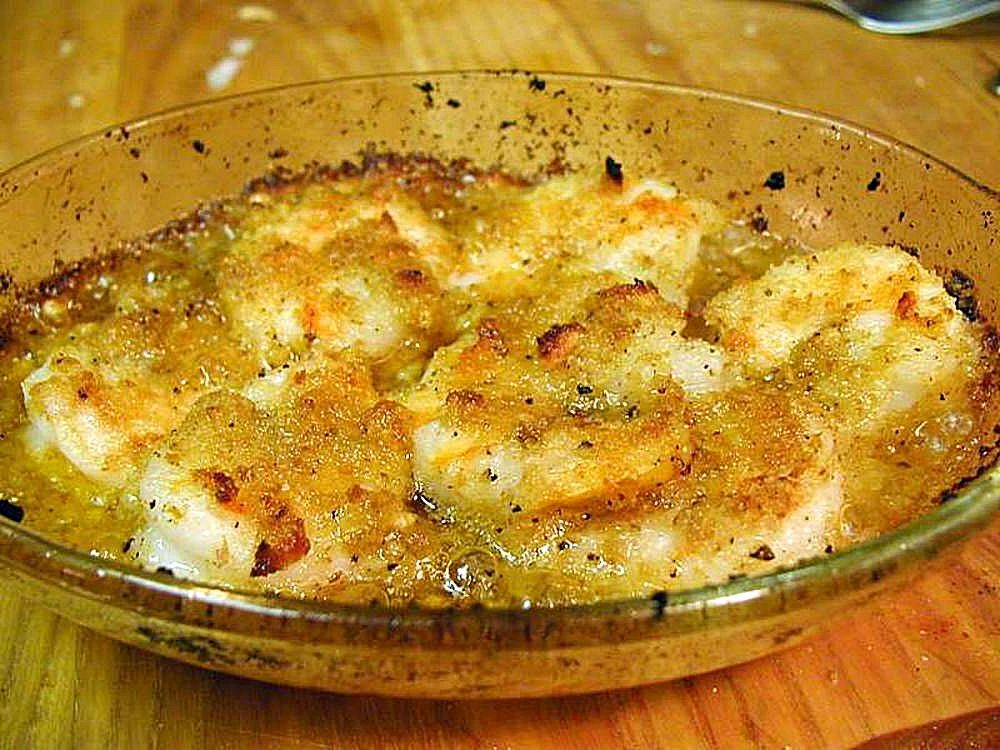 Baked shrimp scampi with a golden breadcrumb topping in a glass baking dish