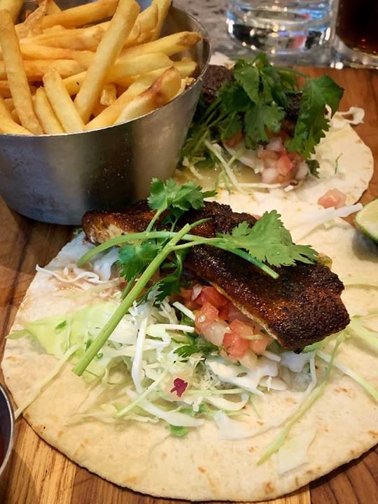 Blackened fish taco on a flour tortilla with shredded cabbage, pico de gallo and cilantro