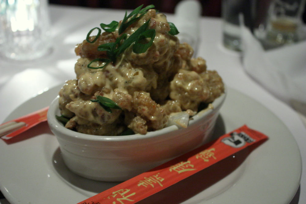 Bonefish Grill bang bang shrimp piled in a small white bowl and topped with sliced green onions