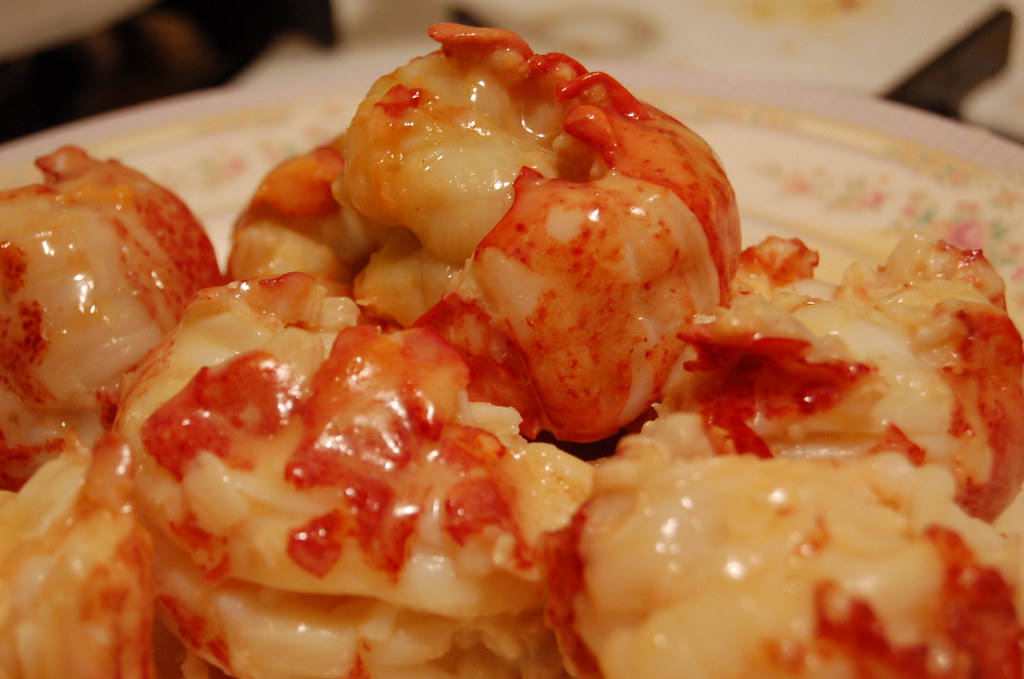 Pieces of butter-poached lobster meat glossy with butter on a plate
