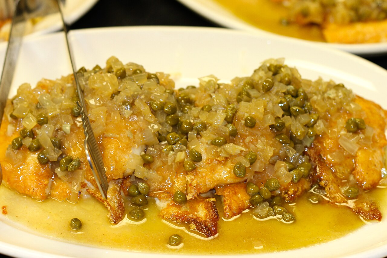 Golden pan-fried flounder fillets covered with capers and shallots in a lemon butter sauce