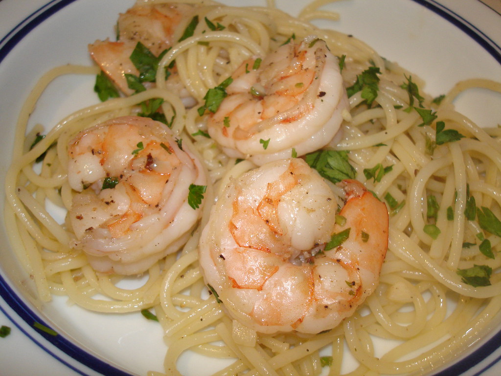Plate of shrimp scampi over spaghetti with chopped parsley